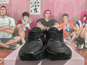 Front view of the pair of black lace-up sneakers showing the toe panels and laces.