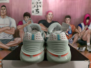 Rear view of the grey Nike sneakers showing padded collars, heel branding, and red accent sections.