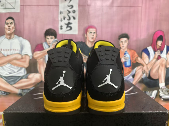 Rear view of black and yellow high-top sneakers showing white heel logos and yellow midsoles.