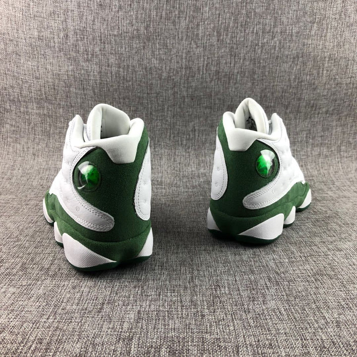 Rear view of white and green Jordan high-top sneakers showing green heel panels and translucent circular details.