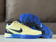 Pair of pale yellow and blue basketball sneakers, including a view of the blue-and-black patterned outsole.