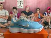 Side profile of a blue and white Nike sneaker showing the contrasting swoosh, perforated upper, and sculpted outsole.