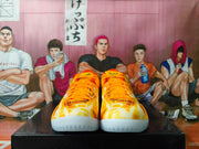 Front view of the shoes showing the patterned toes and orange laces.