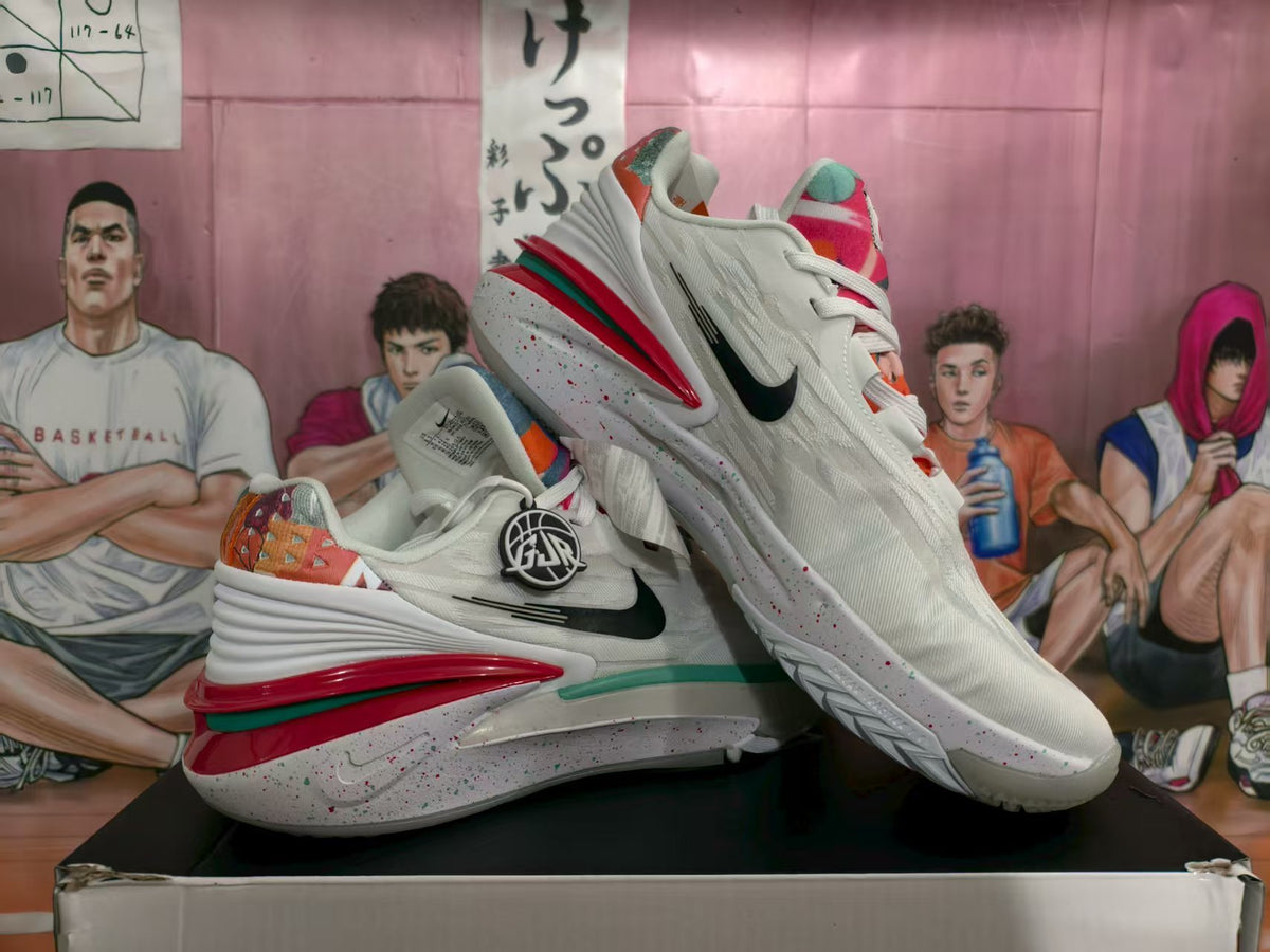 Pair of white Nike basketball sneakers with black Swooshes, multicolor accents, red and green outsole details, and speckled midsoles.