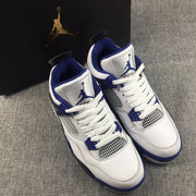 Pair of sneakers photographed beside a black Jordan-branded box, showing the white, black, and blue color scheme.