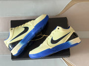Angled top view showing the textured pale yellow uppers, black Swooshes and blue rubber soles.