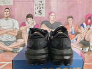 Rear view of a pair of black Brooks shoes showing dotted heel accents.