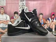 Two black basketball shoes with white Swoosh logos and light-colored collar lining.