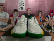 Front view showing the white toe boxes, white laces, green outsole edges and yellow side accents.