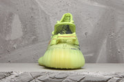 Rear view of a lime green knit sneaker showing the heel and padded collar.