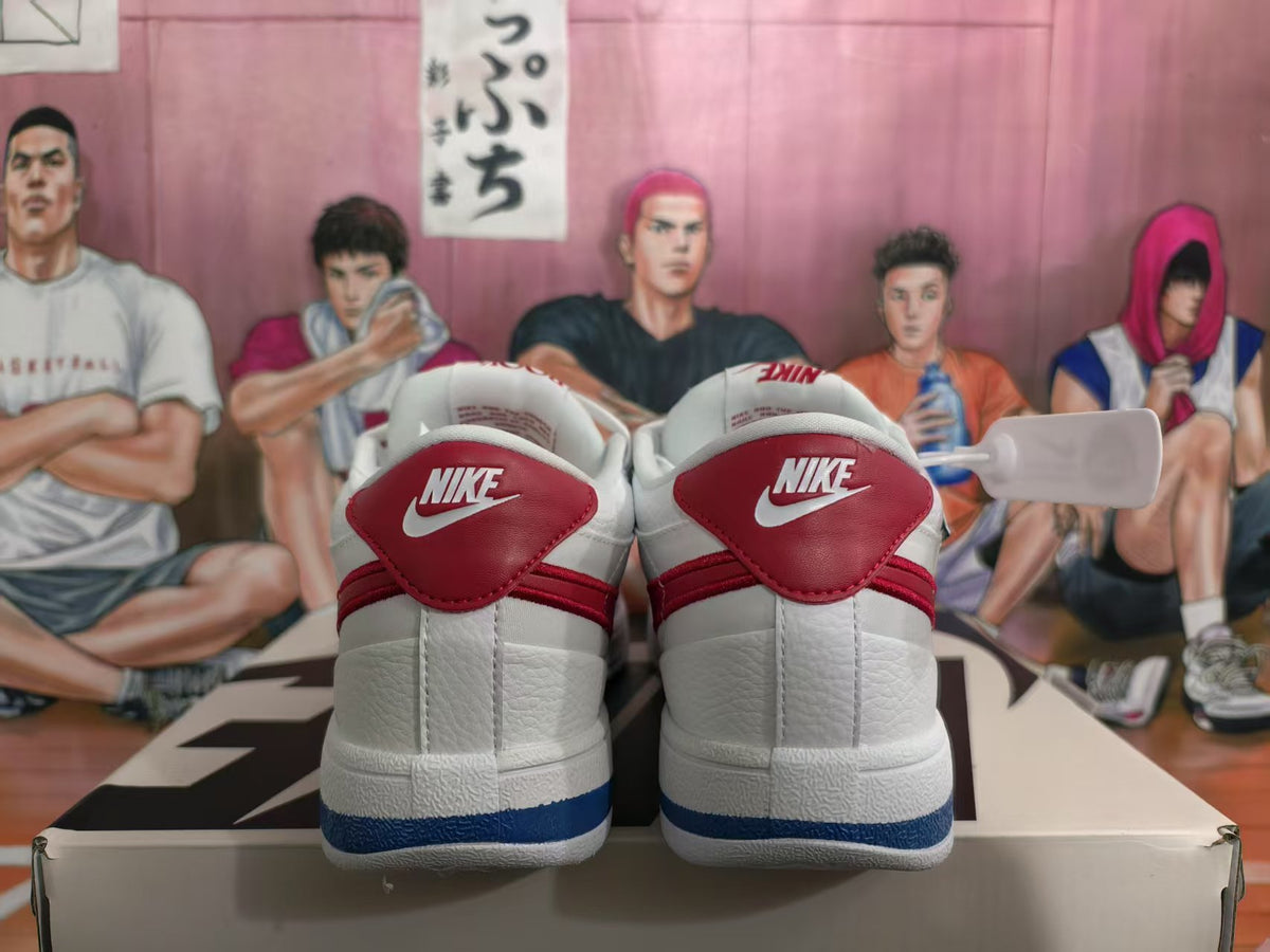 Rear view of white Nike sneakers with red heel panels and blue outsole detailing.