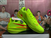 Angled view showing the side and upper of volt-green Nike basketball shoes with red accents.