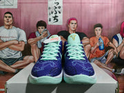 Front view of a pair of blue-purple basketball sneakers with pale mint laces and tongue details.