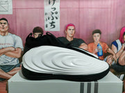 Side profile of a black and white basketball shoe with sculpted white panels and a black outsole.