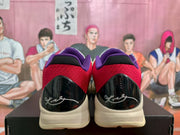 Rear view showing red heel panels, purple collars, glossy black heel sections, and light-colored midsoles.