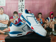 Angled view of white low-top basketball sneakers with blue and red accents