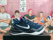 Pair of navy and black Nike basketball sneakers shown from the side on a black box, with white Swoosh logos and white midsoles.