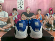 Rear view showing blue heel sections, horizontal white accents, and speckled white heel panels.
