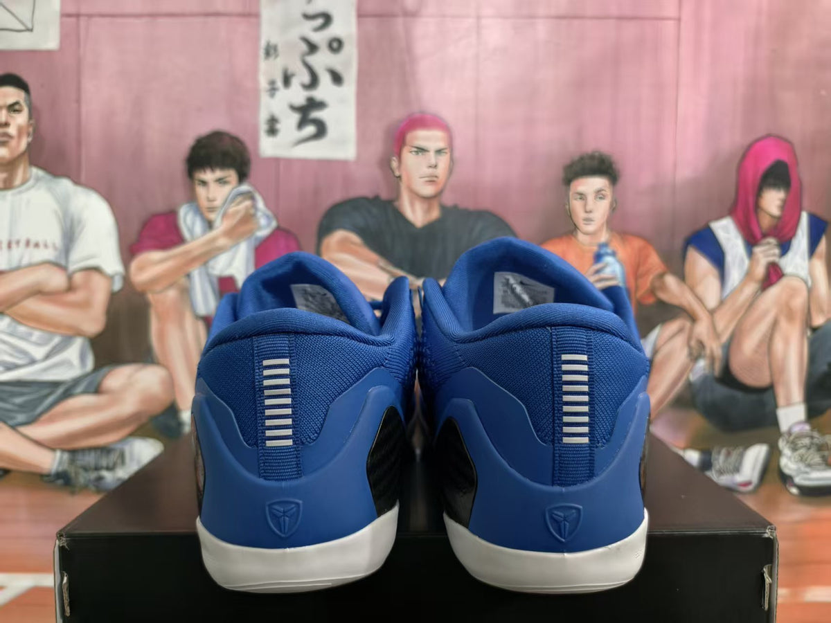 Rear view of blue basketball shoes with white outsoles and heel emblems.