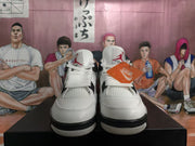 Front view of the white high-top sneakers showing the tongues, laces, mesh panels, and black outsole sections.