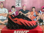 Side profile of a black and red Nike sneaker showing the Swoosh, layered panels, and sculpted outsole.