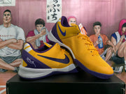 Pair of yellow and purple Nike basketball shoes shown from the side