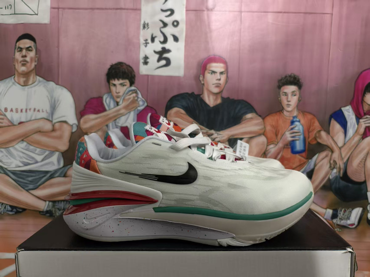 Side view of white Nike basketball sneakers with black Swooshes, red and green midsole accents, and multicolor heel details on a shoebox.