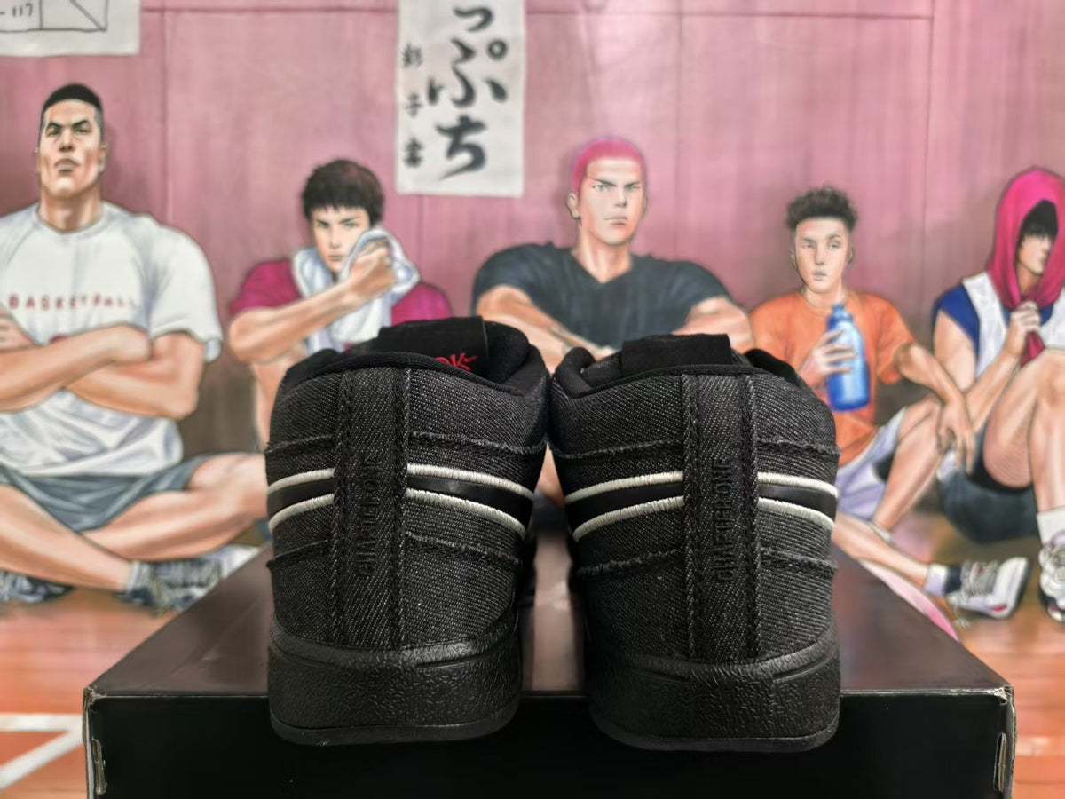 Rear view of a pair of black Nike sneakers on a black shoebox, showing padded collars and contrasting horizontal side detailing.