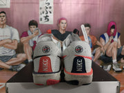 Rear view showing Nike branding, contrasting heel panels, and speckled midsoles.