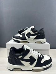 Close angled view of the black-and-white sneakers highlighting the perforated toe, padded collar and side arrow motif.