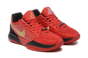 Close-up of the pair showing red uppers, laces, and gold side details