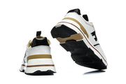 Rear and outsole views of white sneakers with tan-gold heel accents and black tread.
