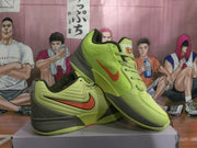 Angled view of the green and orange Nike basketball sneakers showing the side branding, padded collar, and lace-up construction.