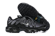 Nike Air Max Plus sneakers shown from the side and outsole, highlighting the patterned upper and tread.