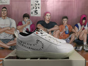 Side profile of a white low-top sneaker with black Nike side branding, stitched graphic details, white laces, and a translucent-looking outsole.
