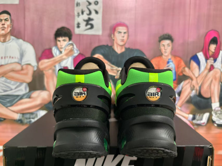 Rear view of black and green Nike Air Max sneakers showing the heel branding and layered black heel construction.