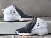 Pair of white and black high-top sneakers shown from the side on a light sofa.