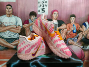 Three-quarter view showing the pink upper, orange laces, purple-and-gold Swoosh, and pale textured outsole.