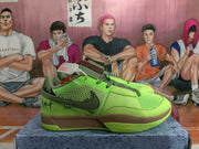 Side profile of a green Nike basketball sneaker showing the dark Swoosh, mesh panel, brown midsole, and low-top shape.