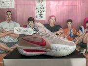 Side profile of a gray and pink sneaker with a pink Nike Swoosh and speckled midsole.