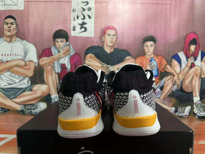 Rear view of black and white basketball shoes with patterned heels and yellow heel accents