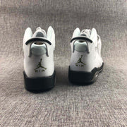 Rear view of the white and black Jordan Air Jordan 6 sneakers showing heel branding and textured uppers.