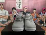 Front view of gray Nike basketball sneakers showing the lace-up design, tongues, mesh-textured uppers, and rubber toe sections.