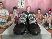 Front view of a pair of black basketball sneakers with contrasting patterned laces and translucent toe outsoles.