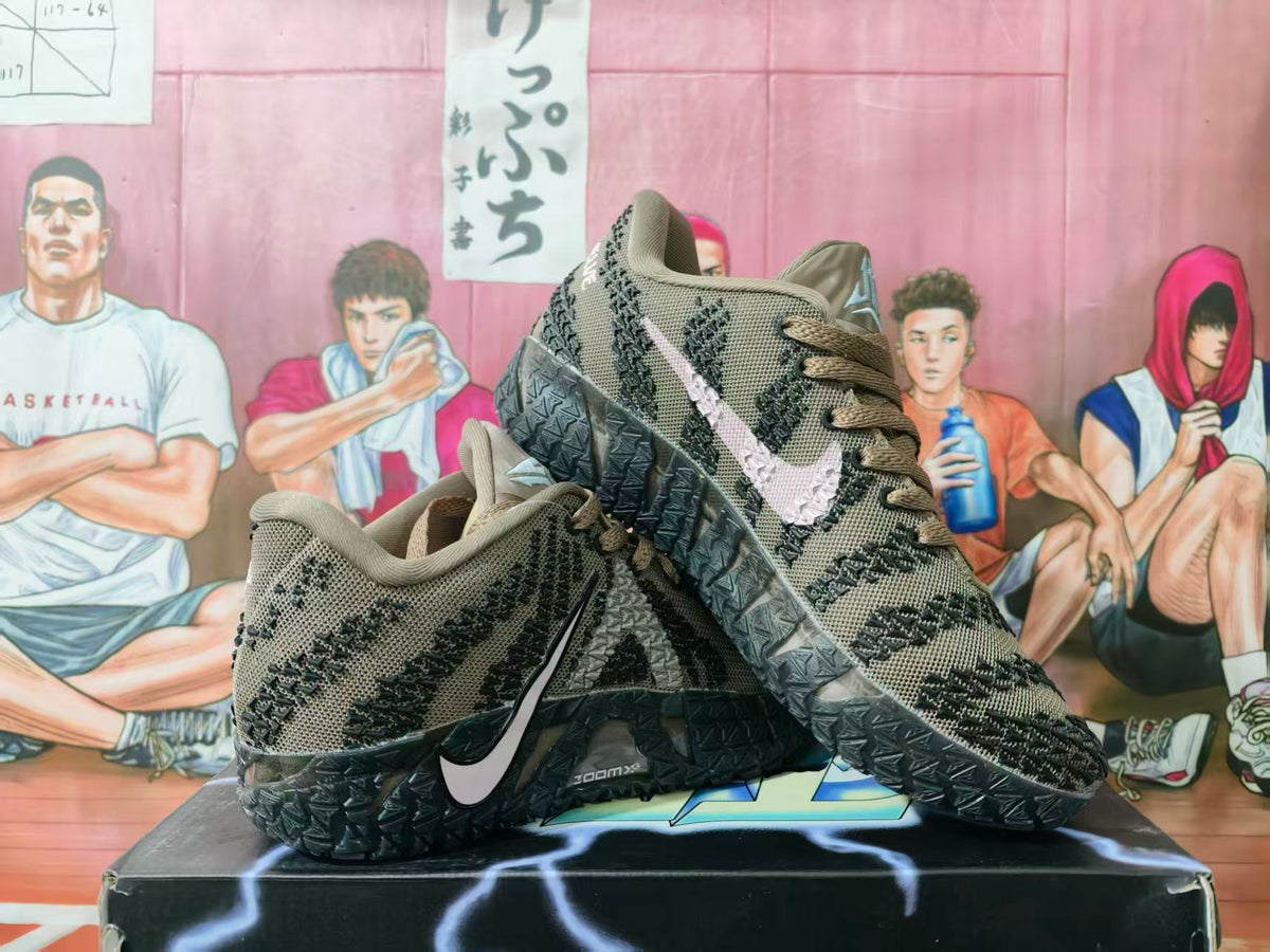 Pair of brown knit Nike sneakers displayed on a shoebox, showing black patterned detailing, contrasting Swooshes, and textured black outsoles.