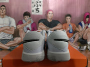 Rear view of a pair of light-colored Nike basketball sneakers showing textured heel panels and black Swoosh details.