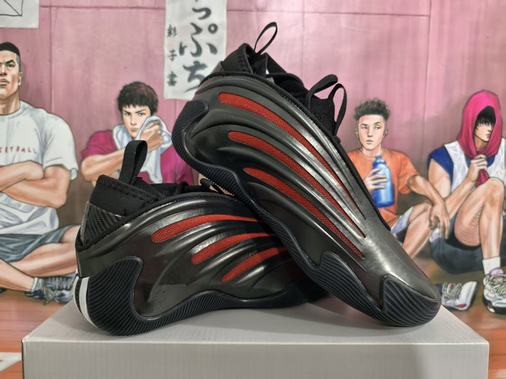 Black sneakers with red mesh side accents, shown from the side and outsole.