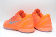 Pair of bright orange Nike basketball sneakers shown from the rear and side, with silver Swoosh details and translucent outsoles.