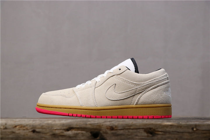 Side view of gray and white low-top Jordan sneakers with a gum-colored midsole and bright pink outsole.