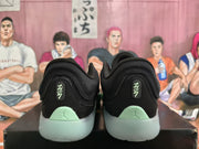 Rear view of the black and mint green Jordan sneakers showing heel branding and pale green outsole sections.
